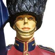 British royal guard statue in ornate old world European style uniform, tall bearskin hat, holding a flag, classical military theme Different Angle
