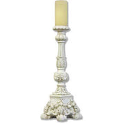 Ornate Baroque candlestick holder with intricate classical detailing and sculpted base, topped with a pillar candle.