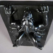 Baroque-style ornate plaque featuring a dramatic, winged figure in relief with outstretched arms and flowing drapery. Side Angle