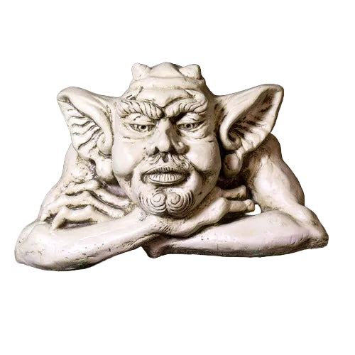 Grotesque gargoyle head with pointed ears and ornate facial features in a medieval Gothic style, resting on crossed arms. Side View