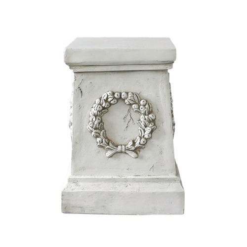 Square pedestal with ornate classical wreath relief, featuring old world European and Baroque-inspired architectural detailing. Side Angle