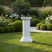 Classical Greek column pedestal with a round top, fluted shaft, and stepped base in an old world European architectural style. Side Angle