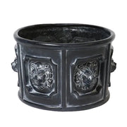 Ornate round planter with classical lion head reliefs in an old world European Baroque style, featuring detailed sculptural panels. Side View