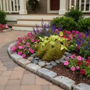 Ornate old world European planter with scalloped, wavy rim and classical detailing, filled with leafy green foliage. Side Angle