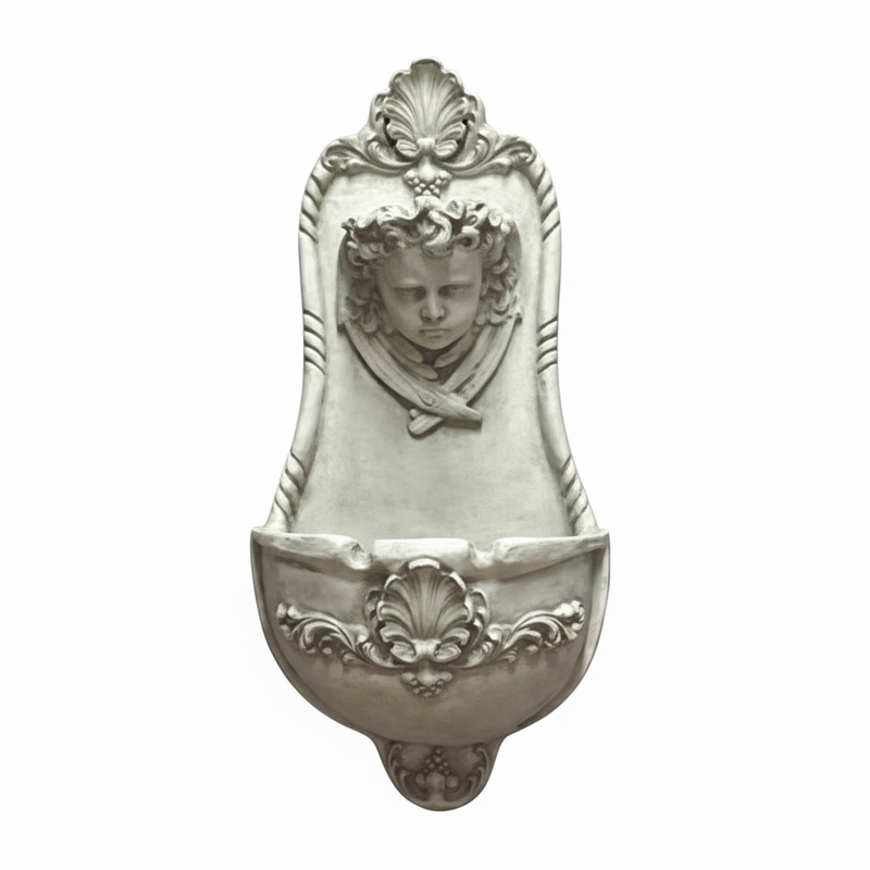 Wall fountain with ornate Baroque detailing, classical cherub face, and intricate scrollwork in old world European style. Side View