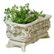 Ornate rectangular planter with classical Baroque relief patterns and intricate scrollwork, featuring lush green foliage. Side View