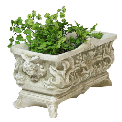Ornate rectangular planter with classical Baroque relief patterns and intricate scrollwork, featuring lush green foliage. Side View