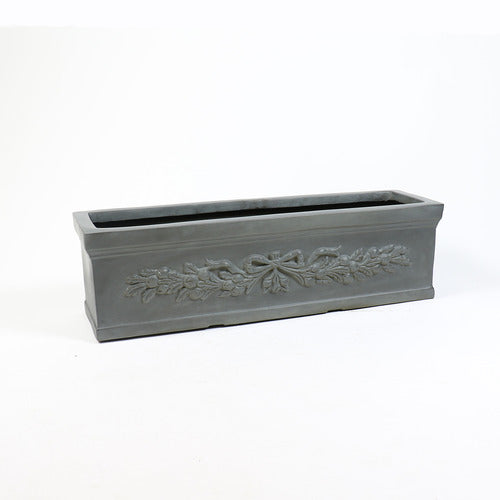 Rectangular planter box with ornate classical relief featuring a bow and garland motif in an old world European style.