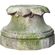 Ornate classical pedestal base with weathered, old world European detailing and leaf motif, evoking a Renaissance architectural style.