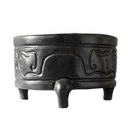 Tripod incense burner with ornate, old world European motifs and classical curved patterns, featuring three sturdy legs and raised reliefs. Side View