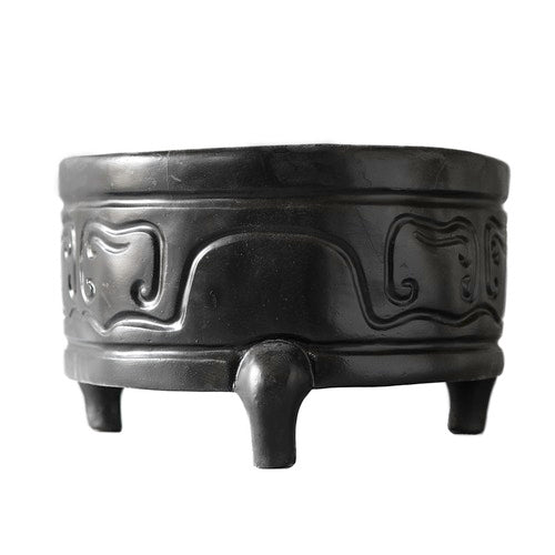 Tripod incense burner with ornate, old world European motifs and classical curved patterns, featuring three sturdy legs and raised reliefs. Side View