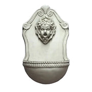 Wall fountain with ornate Baroque design, featuring a classical cherub face and decorative scrollwork in old world European style.