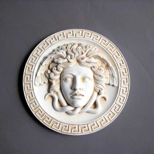 Keyhole escutcheon plate with two screws on a smooth, rounded surface, featuring simple, classical design elements. Side Angle