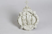 Crucifixion relief in ornate old world European style with classical figures and decorative Baroque frame topped with a cross. Side Angle